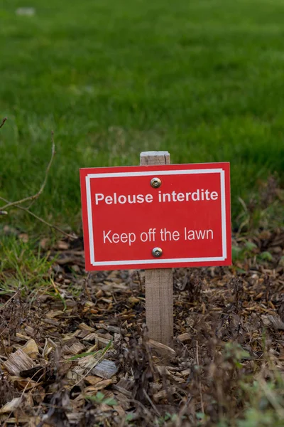 Firma en francés "Keep off the lawn", en un parque — Foto de Stock